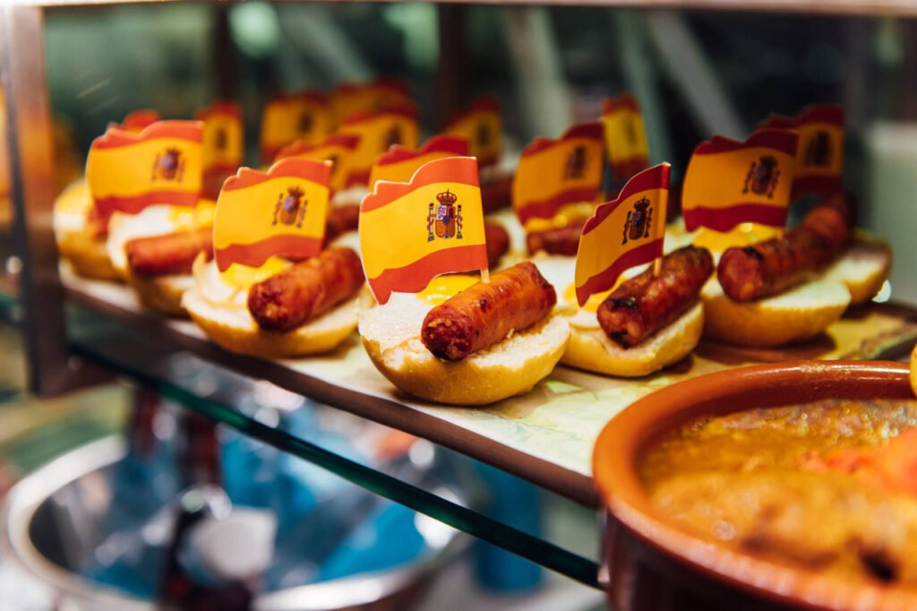 Spanish burger with omelet and souvenir flag of Spain in the market of San Miguel